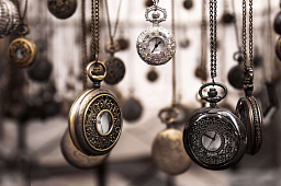 Винтажные карманные часы повешены цепями в антикварном магазине