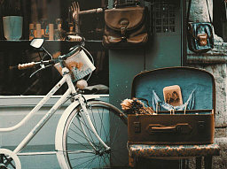 Старый велосипед с деревянной коробкой на улице, на фоне антикварной лавки